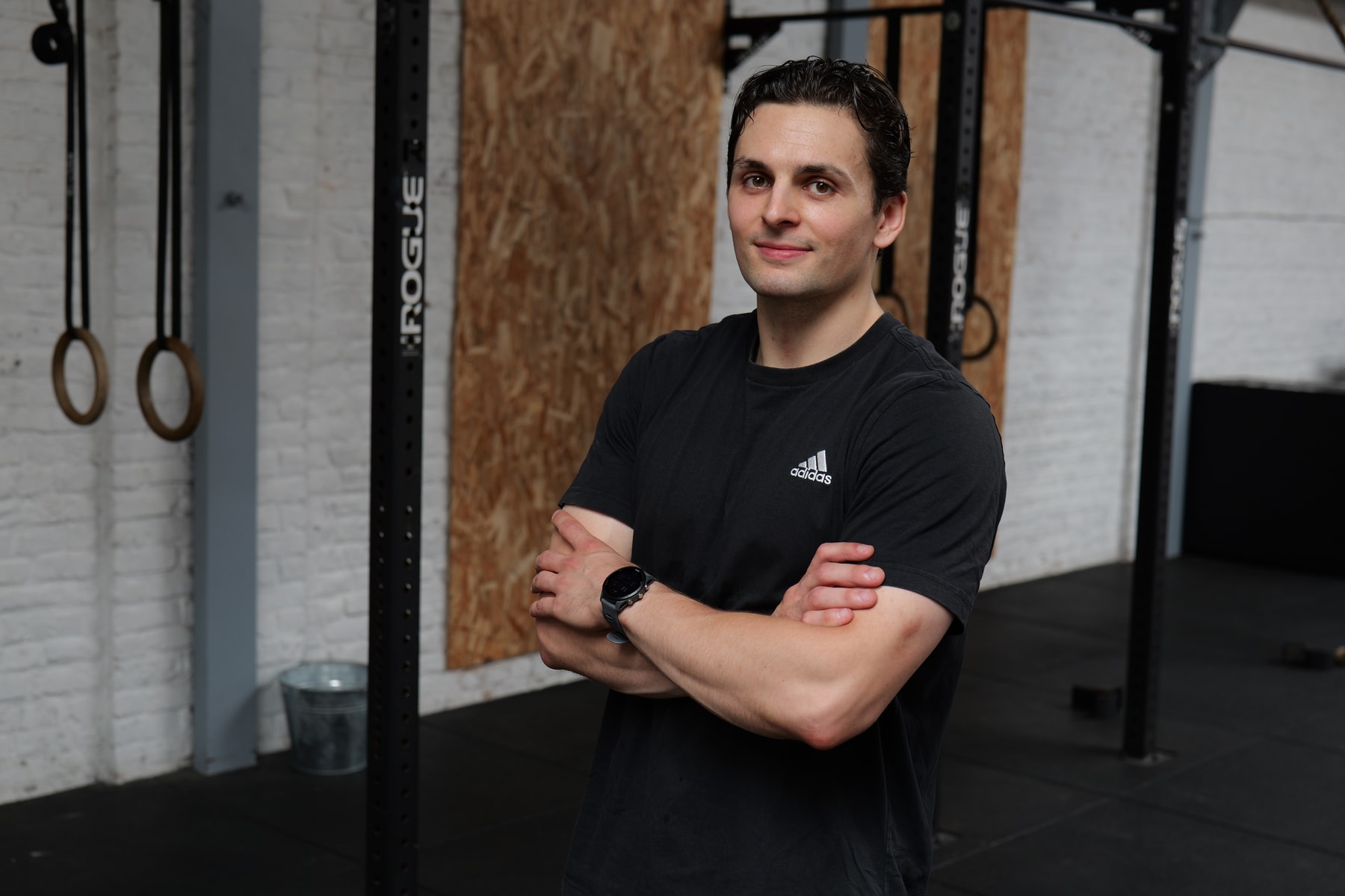 Portrait de Sullyvan, bras croisés, dans une salle d’entraînement.
